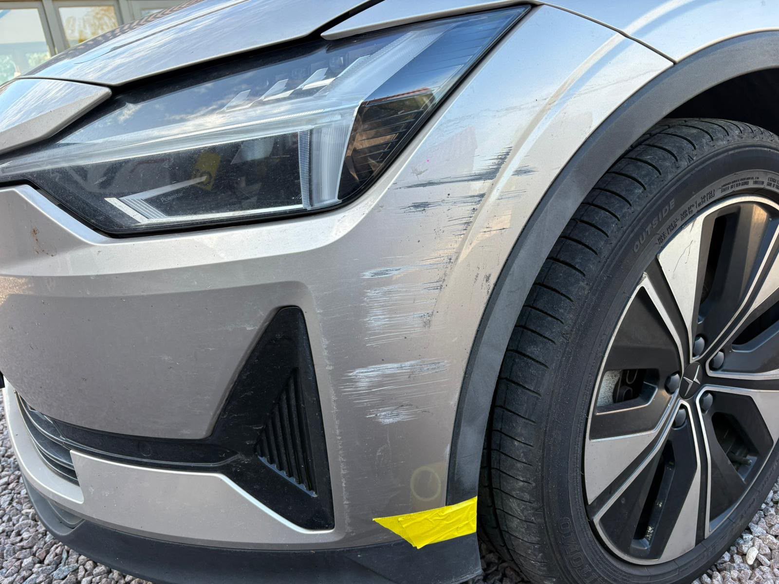 Silver Polestar front wing scratch before repair