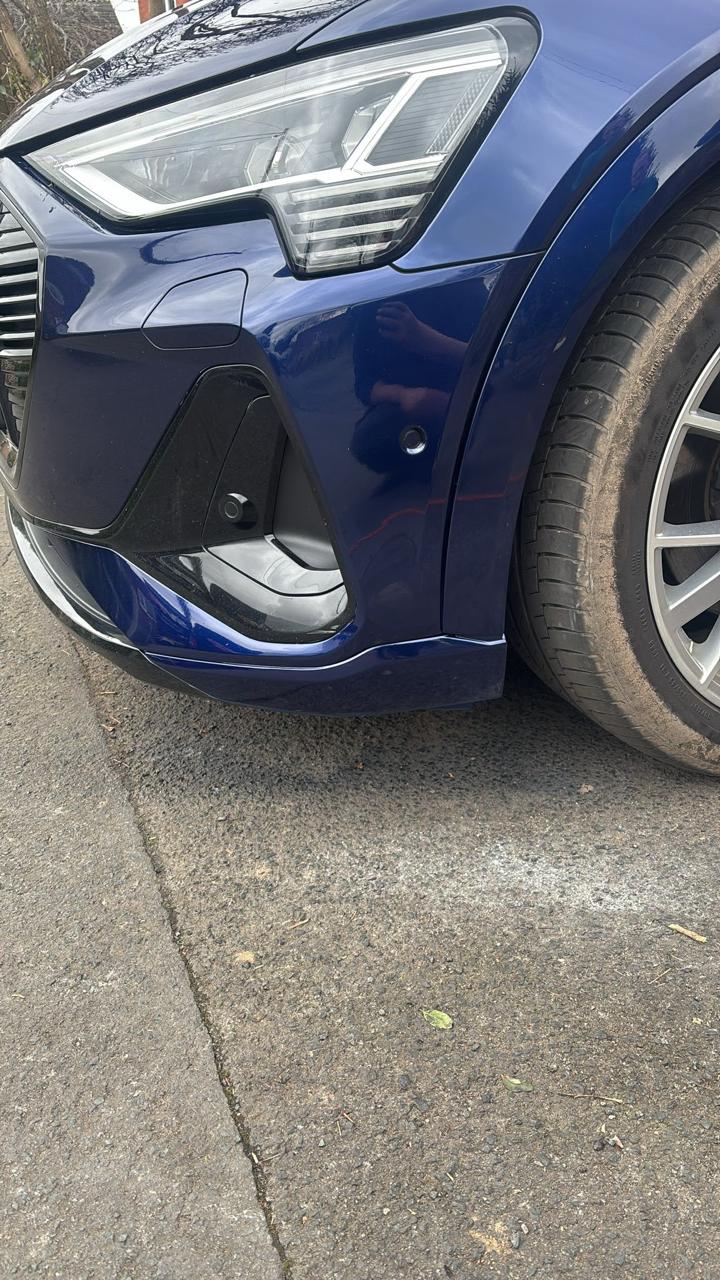 Blue Audi front bumper dent and scuff after repair