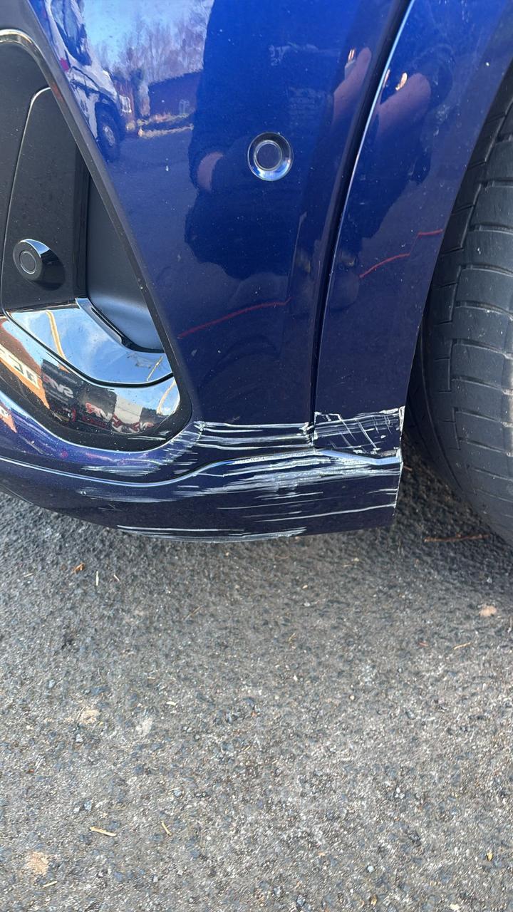 Blue Audi front bumper dent and scuff before repair